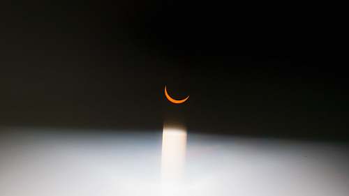 palm coast A red crescent moon surrounded by darkness. black